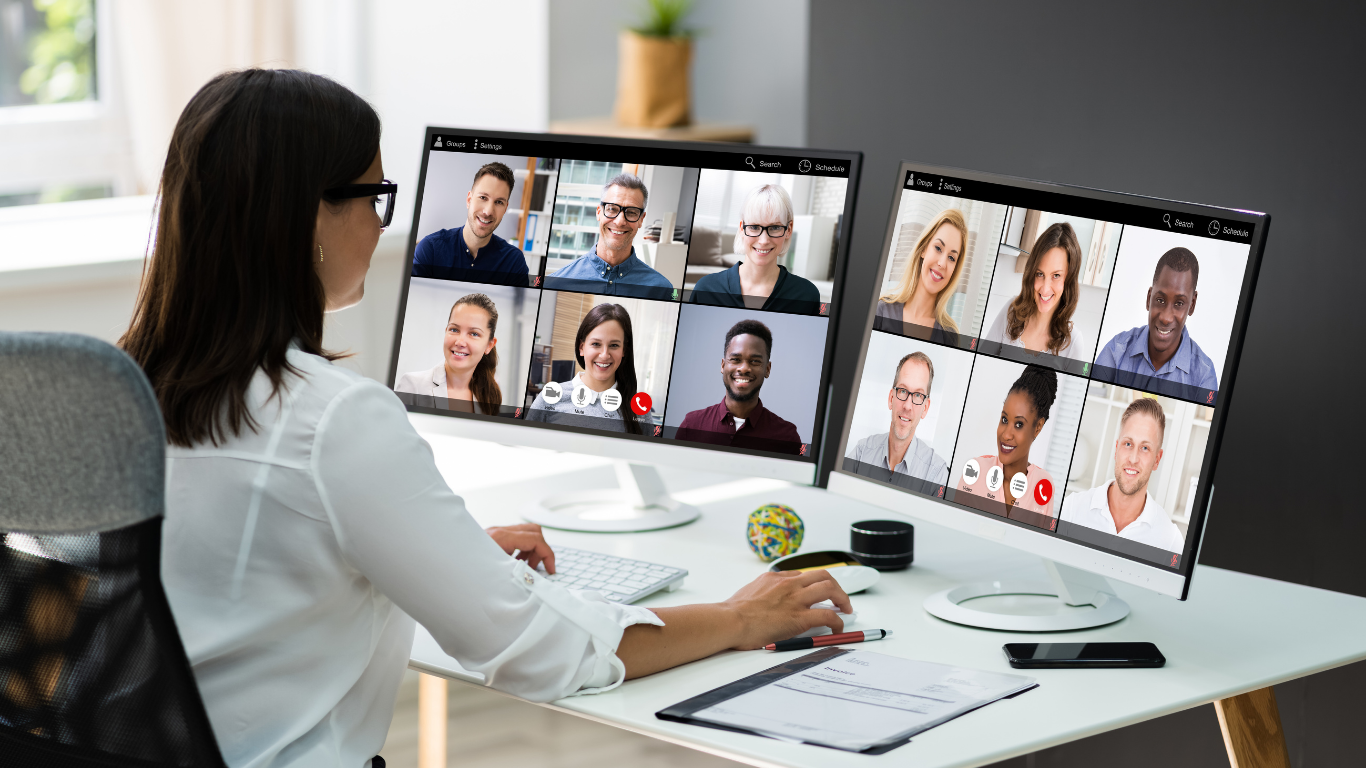 Woman sat in front of her computer in a meeting with her colleagues.